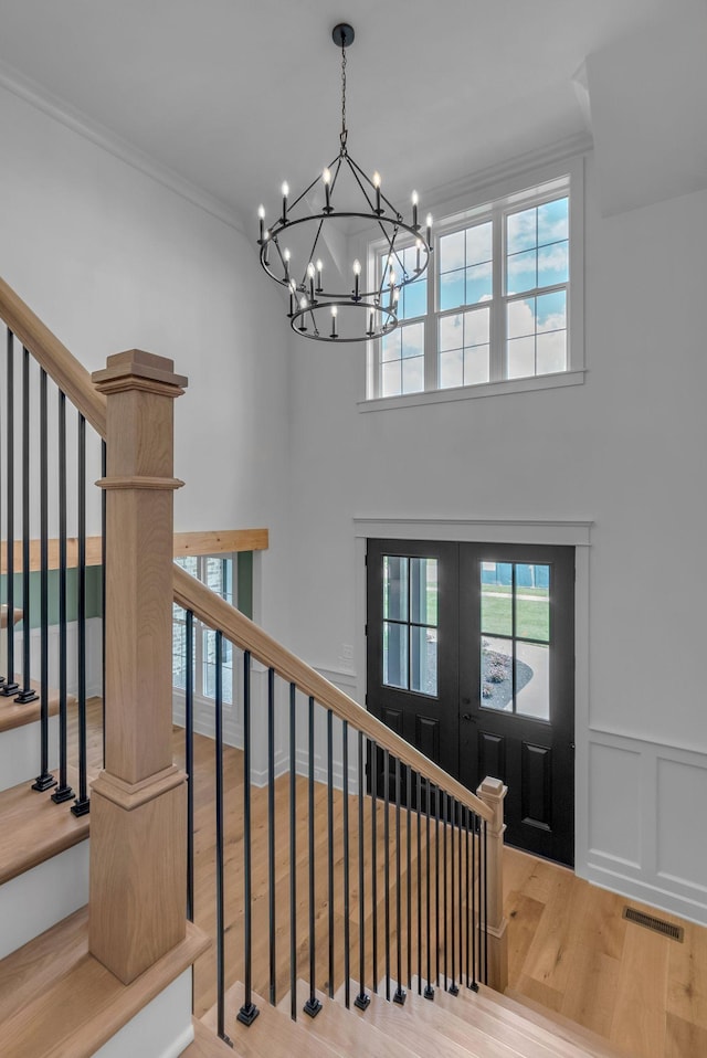 848 Brook Trl, Lebanon, TN 37087 - foyer entrance featuring wood finished floors, french doors, a chandelier, stairs, and wainscoting