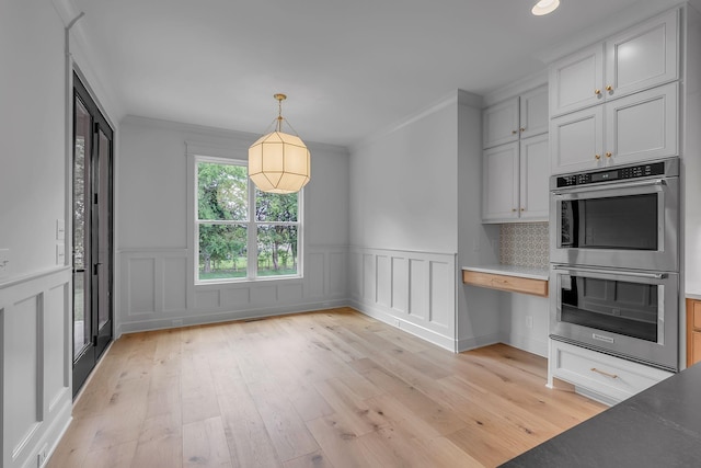 848 Brook Trl, Lebanon, TN 37087 - kitchen with double oven, light wood-type flooring, wainscoting, hanging light fixtures, and a decorative wall