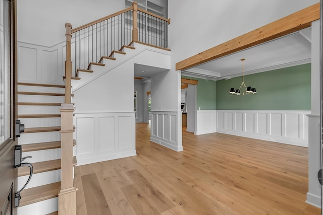 848 Brook Trl, Lebanon, TN 37087 - foyer entrance with a chandelier, light wood-type flooring, a decorative wall, beam ceiling, and a wainscoted wall