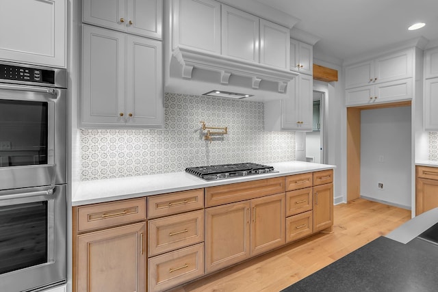 848 Brook Trl, Lebanon, TN 37087 - kitchen featuring stainless steel appliances, light wood-style flooring, tasteful backsplash, light countertops, and recessed lighting