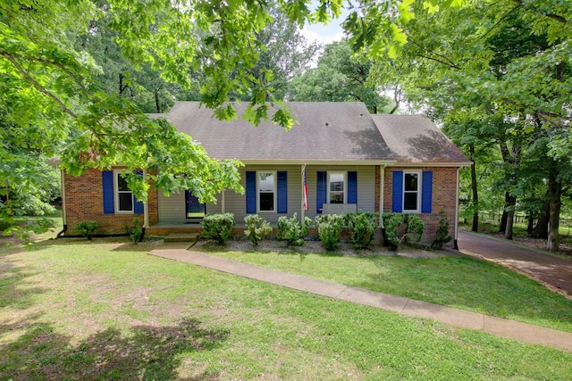 1420 E Rhett Butler Rd, Clarksville, TN 37042 - view of front facade featuring covered porch, a front lawn, brick siding, and roof with shingles