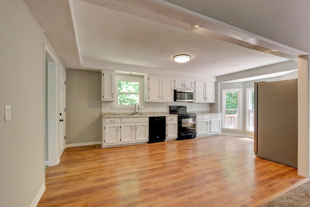 1420 E Rhett Butler Rd, Clarksville, TN 37042 - kitchen with black appliances, white cabinetry, light countertops, baseboards, and a sink