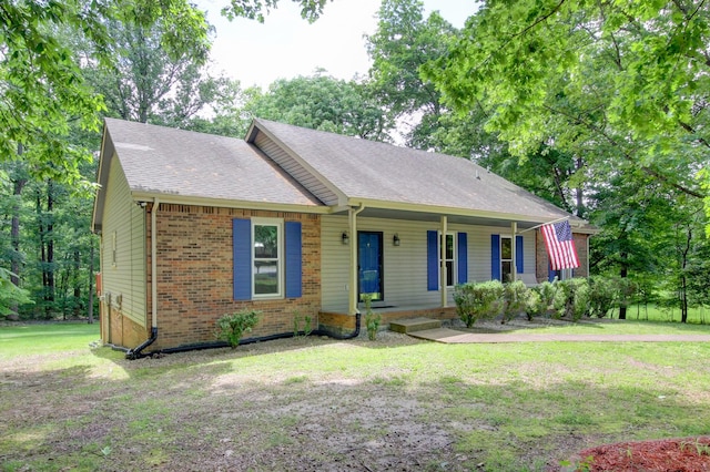 1420 E Rhett Butler Rd, Clarksville, TN 37042 - view of front facade with covered porch, a front yard, brick siding, and roof with shingles