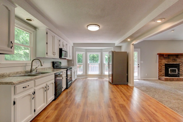 1420 E Rhett Butler Rd, Clarksville, TN 37042 - kitchen with black appliances, a sink, white cabinets, healthy amount of natural light, and a textured ceiling