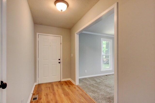 1420 E Rhett Butler Rd, Clarksville, TN 37042 - doorway with baseboards, a textured ceiling, light wood-style flooring, and ornamental molding