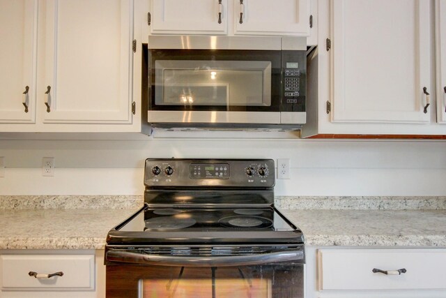 1420 E Rhett Butler Rd, Clarksville, TN 37042 - kitchen featuring stainless steel microwave, black electric range oven, and white cabinets