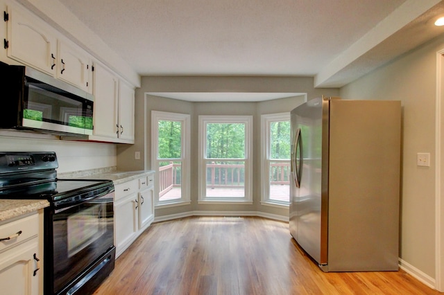 1420 E Rhett Butler Rd, Clarksville, TN 37042 - kitchen featuring appliances with stainless steel finishes, light countertops, white cabinets, and light wood-style flooring