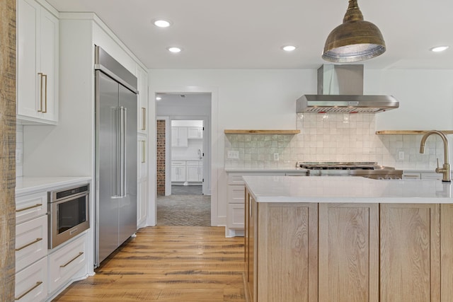 4824 Leipers Creek Rd, Williamsport, TN 38487 - kitchen featuring wall chimney exhaust hood, stainless steel appliances, light wood-type flooring, light countertops, and tasteful backsplash