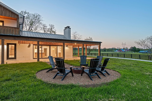 4824 Leipers Creek Rd, Williamsport, TN 38487 - rear view of property with a chimney, a fire pit, brick siding, a standing seam roof, and metal roof
