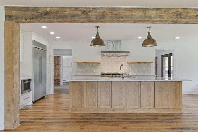 4824 Leipers Creek Rd, Williamsport, TN 38487 - kitchen featuring wall chimney range hood, appliances with stainless steel finishes, light countertops, a sink, and wood finished floors