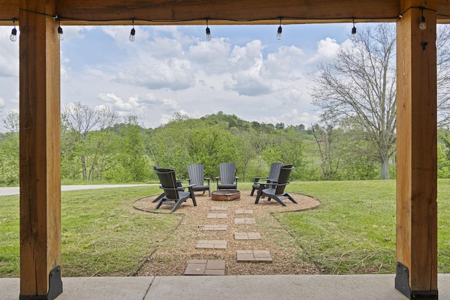 4824 Leipers Creek Rd, Williamsport, TN 38487 - view of green lawn with an outdoor fire pit, a forest view, and a patio