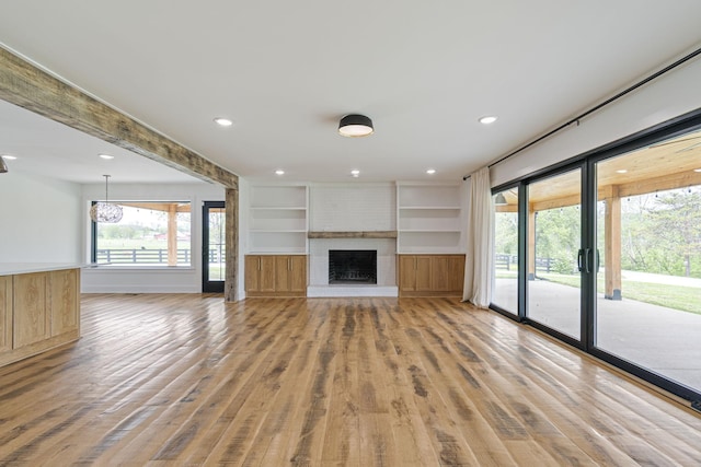 4824 Leipers Creek Rd, Williamsport, TN 38487 - unfurnished living room featuring light wood-type flooring, healthy amount of natural light, built in shelves, a fireplace, and recessed lighting