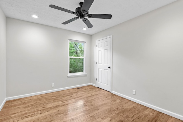 empty room with light wood finished floors, baseboards, ceiling fan, recessed lighting, and a textured ceiling
