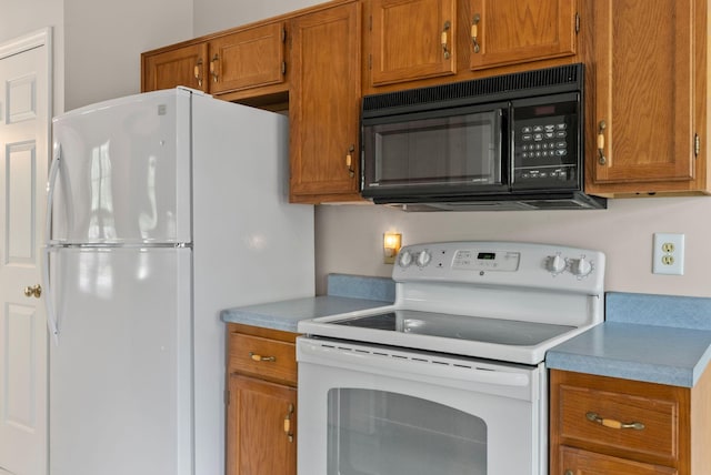 kitchen featuring white appliances, brown cabinets, and light countertops