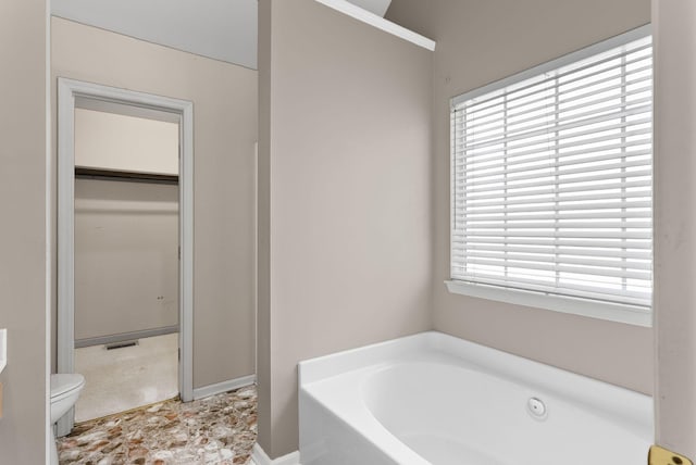 bathroom featuring a bath and toilet