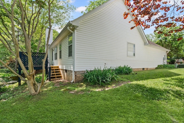 view of side of property with a lawn and crawl space
