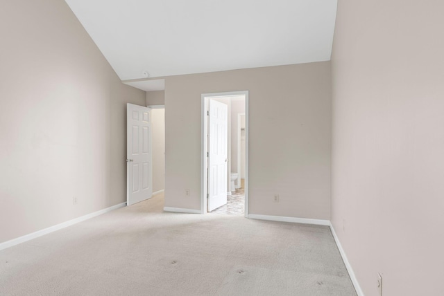 unfurnished room featuring light carpet and baseboards