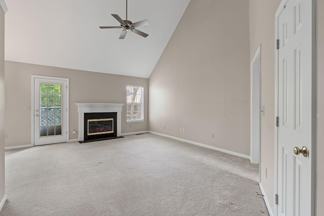 unfurnished living room featuring high vaulted ceiling, carpet floors, a ceiling fan, baseboards, and a fireplace with flush hearth