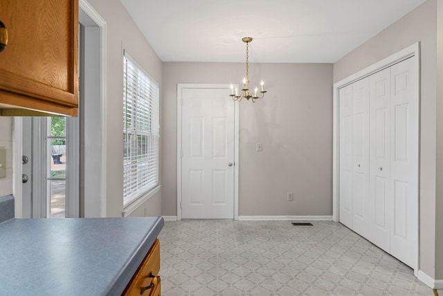 dining room with light flooring, a chandelier, and baseboards