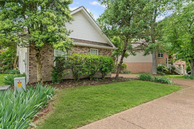 view of property exterior featuring a lawn and brick siding
