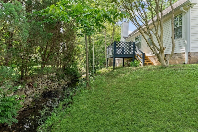 view of grassy yard with a deck