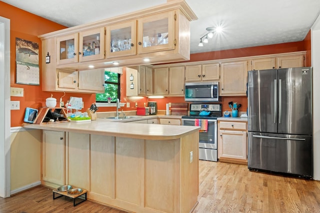 1015 Cross Country Dr, Kingston Springs, TN 37082 - kitchen with appliances with stainless steel finishes, a sink, a peninsula, light countertops, and light wood finished floors