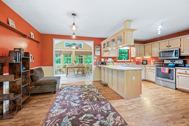 1015 Cross Country Dr, Kingston Springs, TN 37082 - kitchen with stainless steel appliances, a sink, light wood finished floors, light countertops, and glass insert cabinets