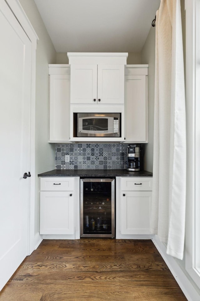 273 Halltown Rd, Cottontown, TN 37048 - bar area featuring wine cooler, stainless steel microwave, tasteful backsplash, and dark wood-style flooring