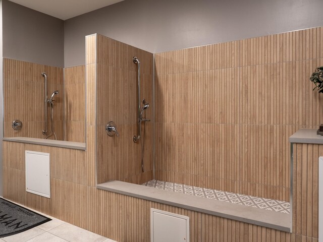 interior space with tiled shower and tile patterned floors