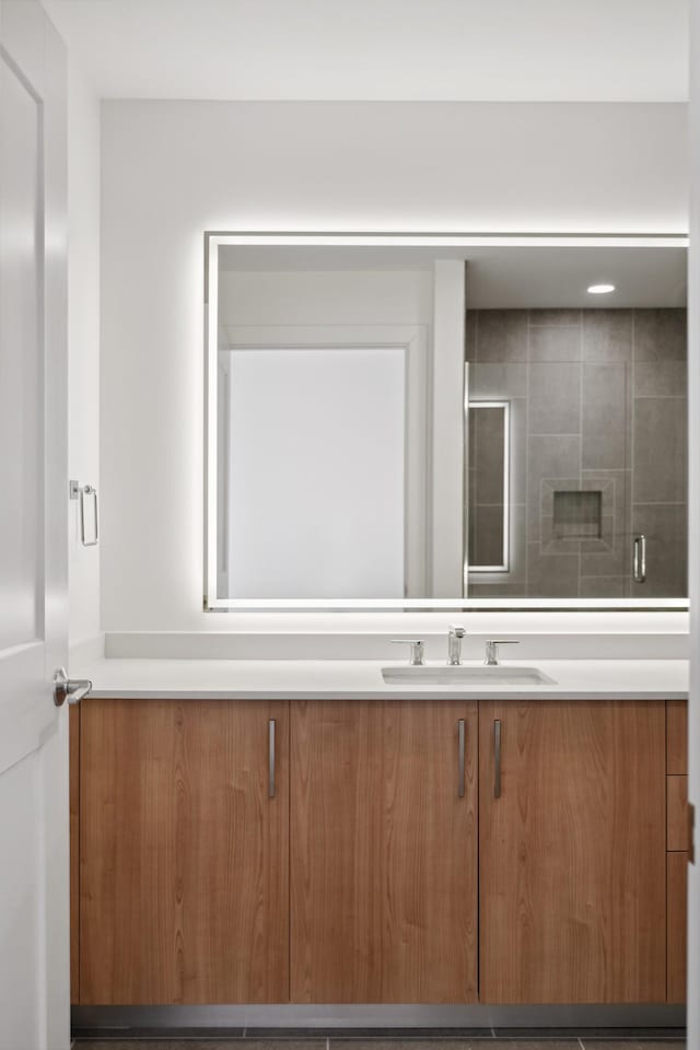 bathroom with vanity and a shower with shower door