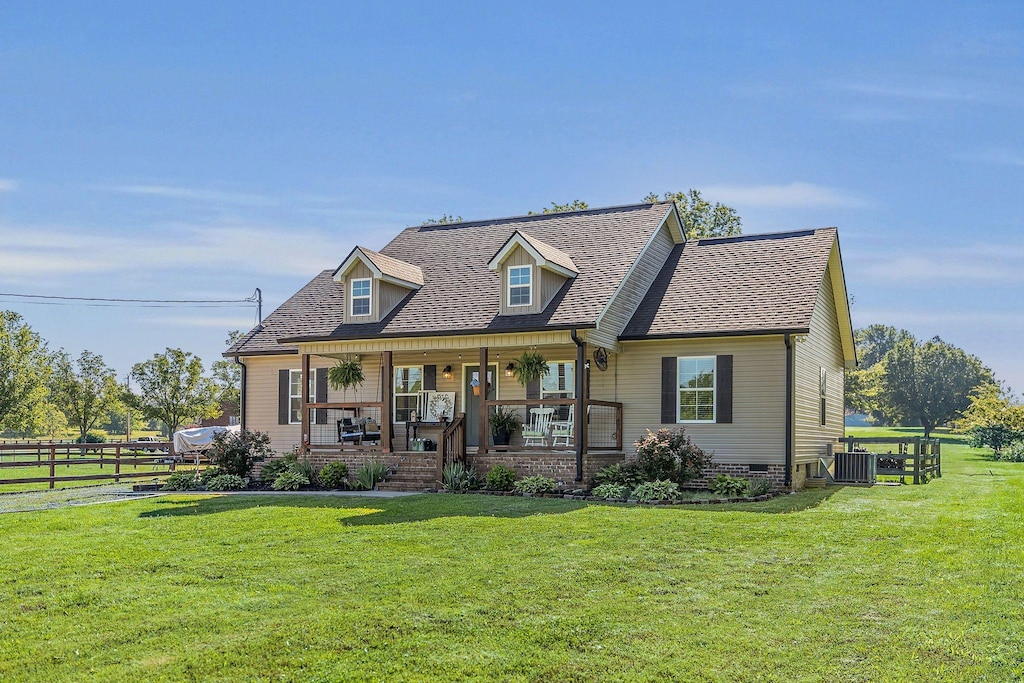 cape cod-style house featuring central AC, covered porch, and roof with shingles