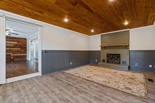 208 Meadowgreen Dr, Franklin, TN 37069 - unfurnished living room featuring crown molding, wood finished floors, a wainscoted wall, ceiling fan, and a fireplace