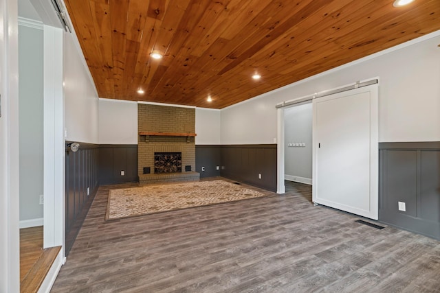 208 Meadowgreen Dr, Franklin, TN 37069 - unfurnished living room featuring wainscoting, wooden ceiling, a barn door, wood finished floors, and crown molding