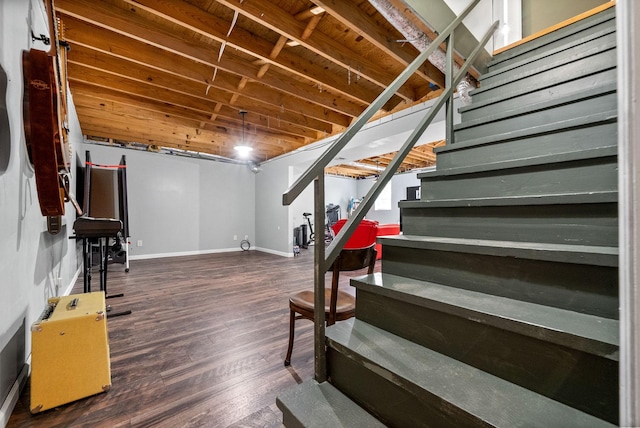 finished below grade area with stairway, baseboards, and wood finished floors