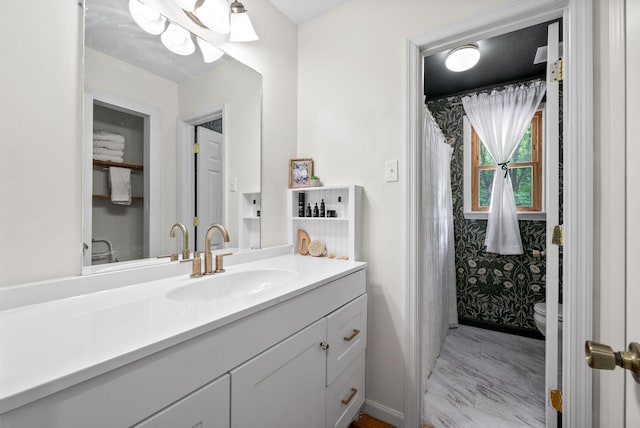 bathroom with vanity, toilet, and baseboards