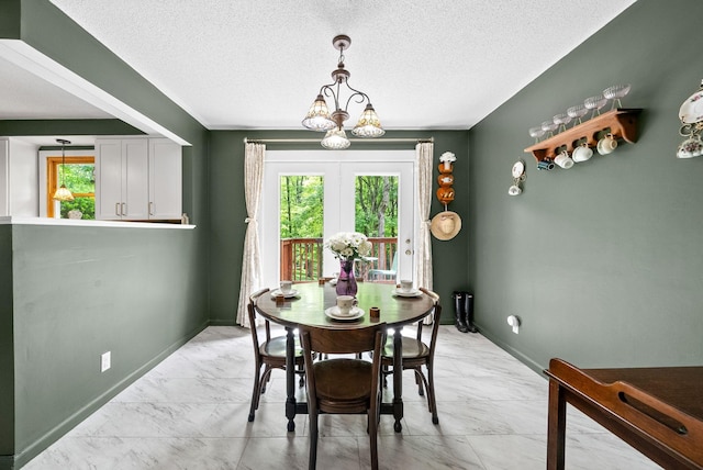 dining space with light marble finish floors, a chandelier, a textured ceiling, and baseboards