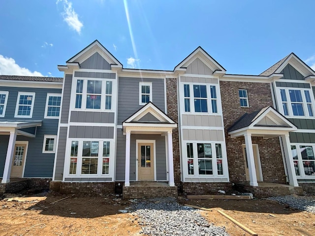 view of front of home featuring board and batten siding and brick siding