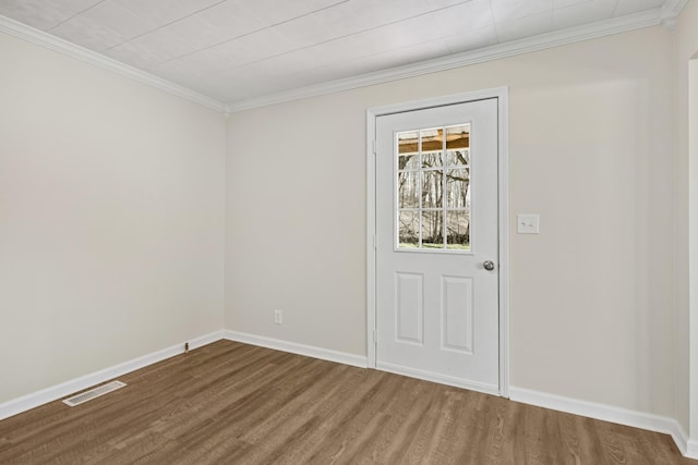 doorway with wood finished floors, ornamental molding, and baseboards