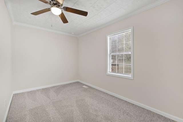 carpeted spare room with baseboards, ornamental molding, and a ceiling fan