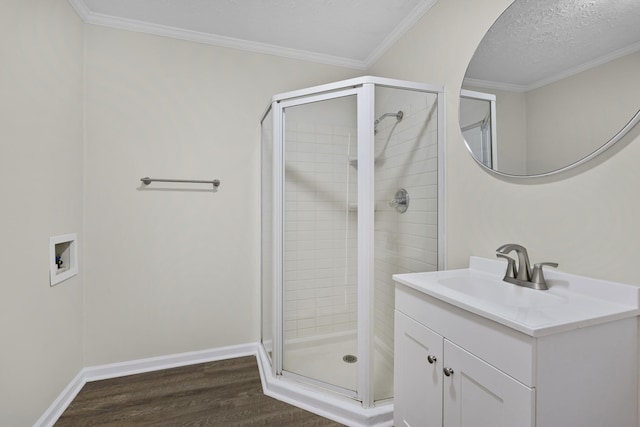 full bathroom with a shower stall, wood finished floors, vanity, a textured ceiling, and crown molding