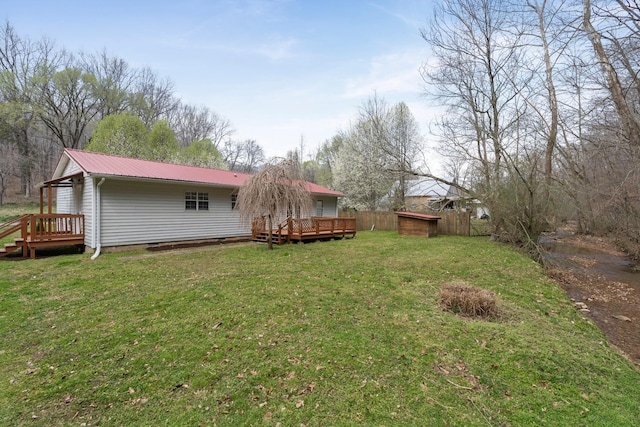 view of green lawn featuring a deck