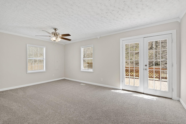 carpeted spare room with plenty of natural light, ceiling fan, ornamental molding, french doors, and baseboards