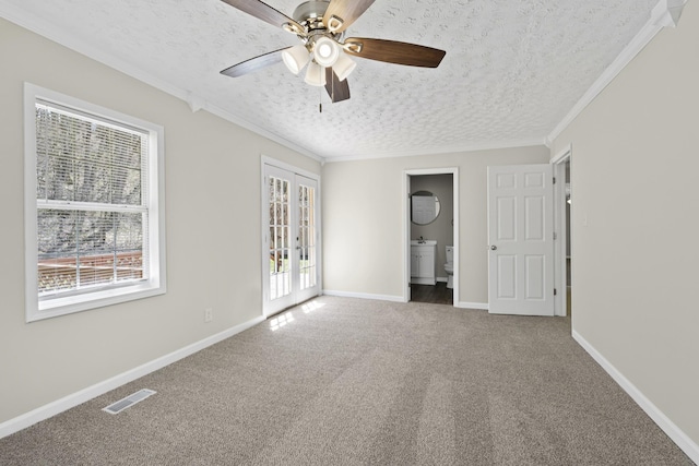 unfurnished bedroom featuring a textured ceiling, multiple windows, carpet floors, ornamental molding, and baseboards
