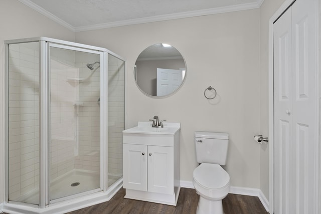 bathroom with wood finished floors, a shower stall, ornamental molding, toilet, and vanity