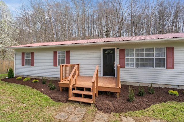 view of front facade featuring a deck, metal roof, and crawl space