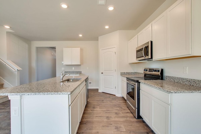 4017 Roane Dr, White House, TN 37188 - kitchen featuring appliances with stainless steel finishes, a sink, wood finished floors, light stone countertops, and recessed lighting