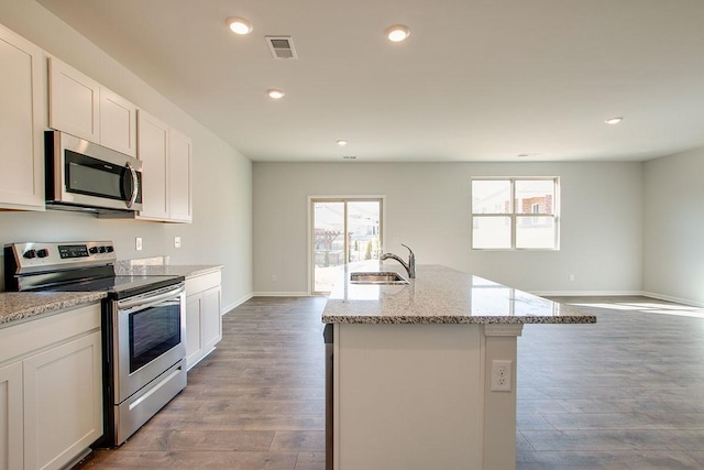 4017 Roane Dr, White House, TN 37188 - kitchen with stainless steel appliances, a sink, wood finished floors, light stone counters, and recessed lighting