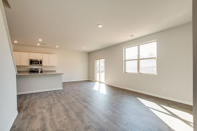 4017 Roane Dr, White House, TN 37188 - unfurnished living room with dark wood-type flooring, baseboards, recessed lighting, and a sink