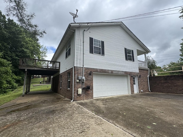 view of property exterior featuring concrete driveway, a garage, a deck, and brick siding