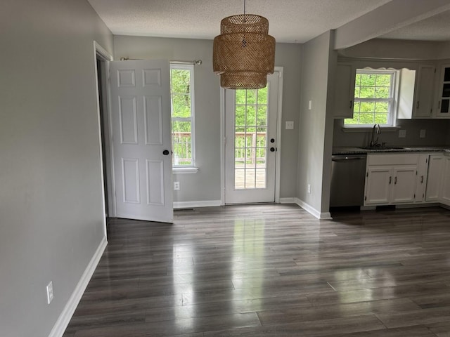 doorway featuring a sink, dark wood-style flooring, baseboards, and a textured ceiling